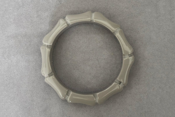 Horizontal bottom view of 2000s y2k vintage gray plastic molded faux bamboo bangle bracelet.