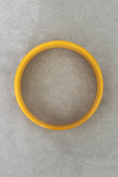 Vertical bottom view of 1940s vintage egg yolk yellow and mustard marbled Bakelite domed bangle bracelet