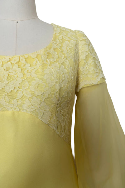 Detail view of 1960s vintage yellow crepe and lace empire waist maxi dress with chiffon bishop sleeves, size extra small to small. Showing the lace overlay to the empire waist bodice and sleeve caps.