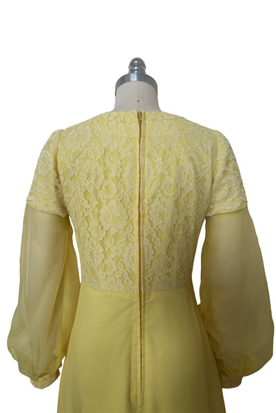 Detail view of 1960s vintage yellow crepe and lace empire waist maxi dress with chiffon bishop sleeves, size extra small to small. Showing the lace overlay to the empire waist bodice and sleeve caps.