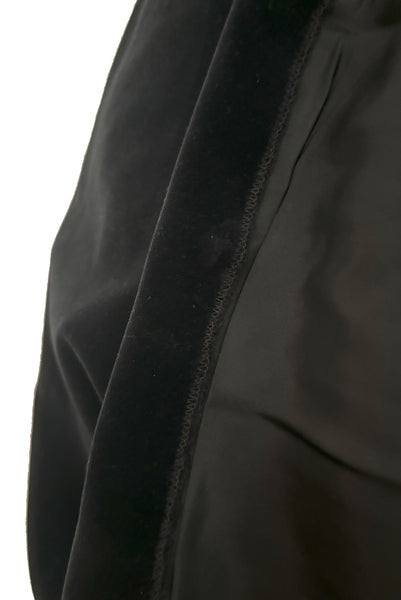 Hem detail view of 1950s vintage black velveteen dress with scalloped lace midriff by Betty Barclay, medium to large. Showing where the hem was cut, serged, and hemmed.