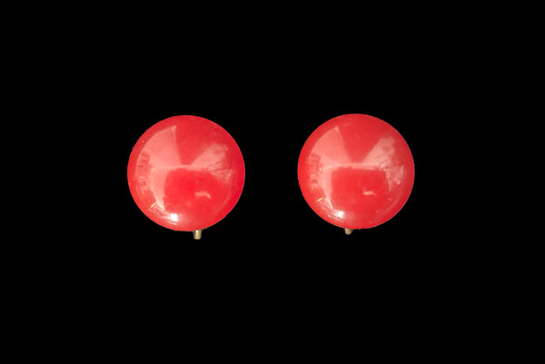 Horizontal front view of 1930s vintage red Bakelite round button screw back earrings.