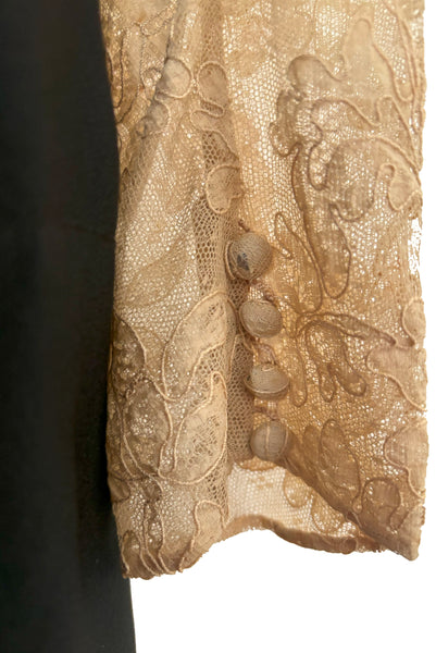 Detail view of 1930s vintage cream lace sheer back Juliet sleeve square neck black crepe midi dress, size extra small to small. Showing some wear to the lace covered buttons on the cuff.