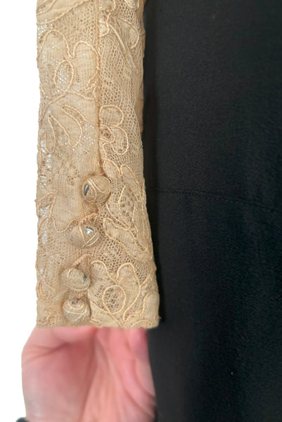 Detail view of 1930s vintage cream lace sheer back Juliet sleeve square neck black crepe midi dress, size extra small to small. Showing some wear to the lace covered buttons on the cuff.
