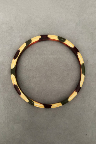 Vertical bottom view of 1960s vintage cream, purple, and green celluloid two (2) bangle bracelet set. Showing a single bangle.