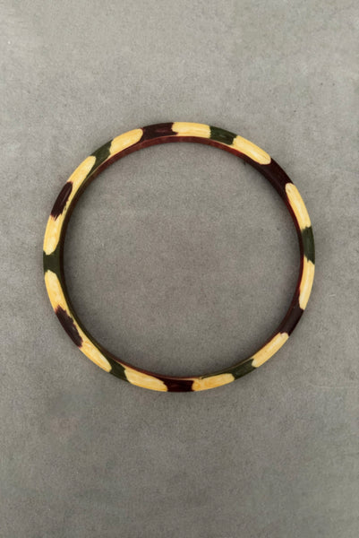 Vertical bottom view of 1960s vintage cream, purple, and green celluloid two (2) bangle bracelet set. Showing a single bangle.