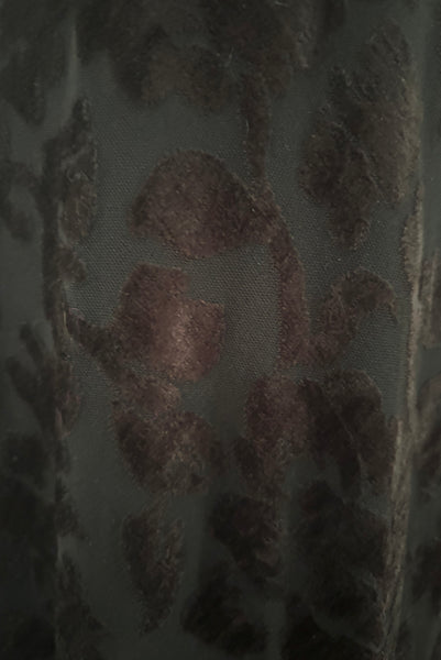 Fabric detail view of new with tags 1990s vintage Art Deco style black floral burnout velvet knit maxi dress, by Kamisato, small to medium. Showing the velvet texture of the burnout knit.