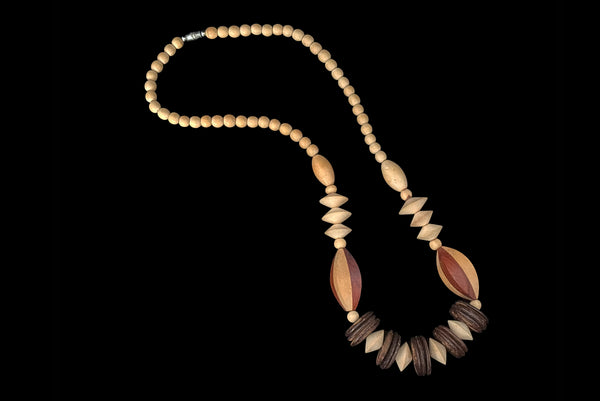 Horizontal view of 1980s vintage carved round and disk bead light, medium, and dark triple tone wood necklace.