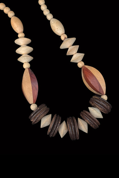 Detail view of 1980s vintage carved round and disk bead light, medium, and dark triple tone wood necklace.