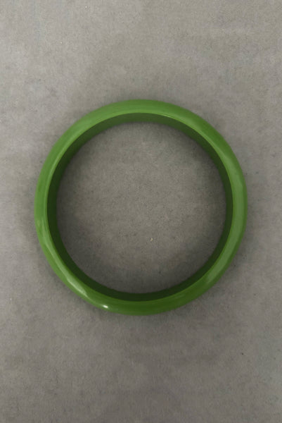 Vertical bottom view of 1980s vintage leaf green two (2) domed, and one (1) saucer three (3) bangle bracelet set. Showing one domed bangle.