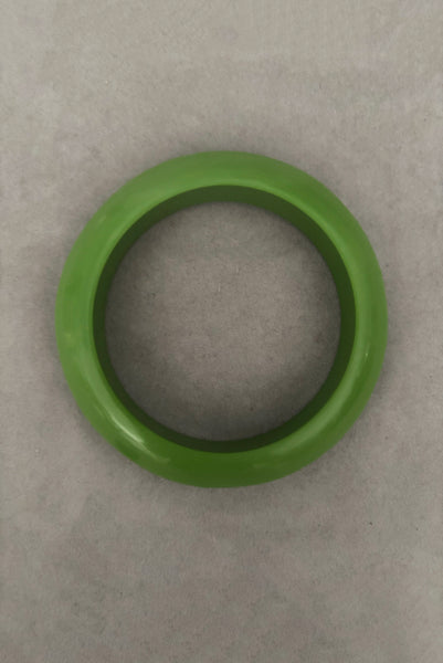 Vertical top view of 1980s vintage leaf green two (2) domed, and one (1) saucer three (3) bangle bracelet set. Showing the saucer bangle.