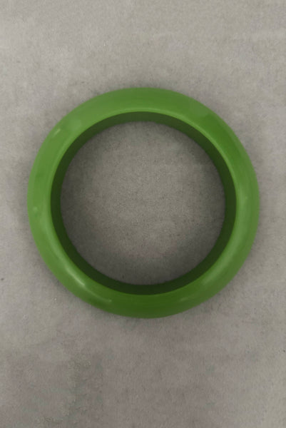 Vertical bottom view of 1980s vintage leaf green two (2) domed, and one (1) saucer three (3) bangle bracelet set. Showing the saucer bangle.
