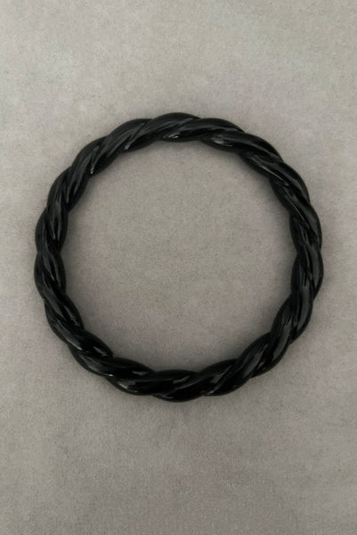 Vertical bottom view of 1980s vintage black plastic twisted, ridged, and orange goldfish painted bangle bracelet set of three (3). Showing the twisted rope bangle only.