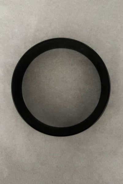 Vertical bottom view of 1980s vintage black plastic twisted, ridged, and orange goldfish painted bangle bracelet set of three (3). Showing the goldfish painted bangle only.