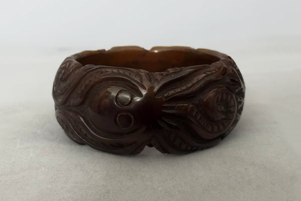 Horizontal front view of 1930s vintage novelty octopus sea life carved green Bakelite statement bangle bracelet.