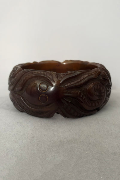 Vertical front view of 1930s vintage novelty octopus sea life carved green Bakelite statement bangle bracelet.