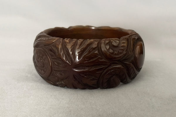 Horizontal side view of 1930s vintage novelty octopus sea life carved green Bakelite statement bangle bracelet.