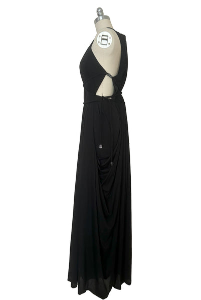 Side view of vintage new with tags 1970s split front black jersey evening dress by Roter Couture, medium to large. Showing the revealing halter neckline, open sides, and draped skirt.