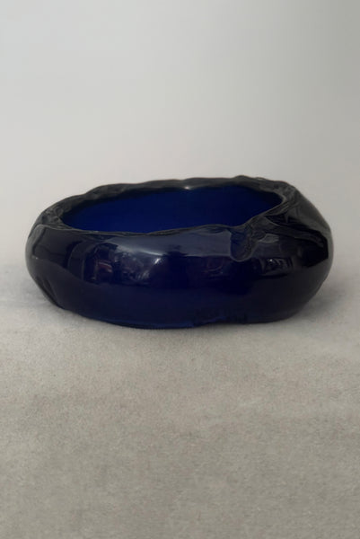 Vertical back view of 1980s vintage artisan carved translucent blue Lucite asymmetrical bangle bracelet.