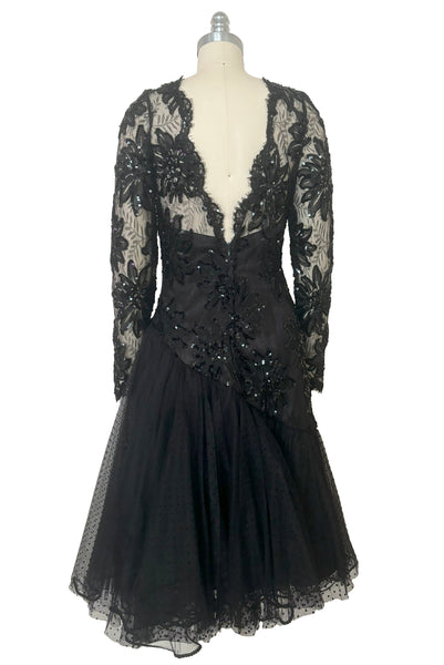 Back view of 1980s vintage black satin, sequin lace, & dotted tulle asymmetrical cocktail dress by Mignon, small to medium. New with tags. Showing the V back neckline and full asymmetrical polka dot tulle skirt.