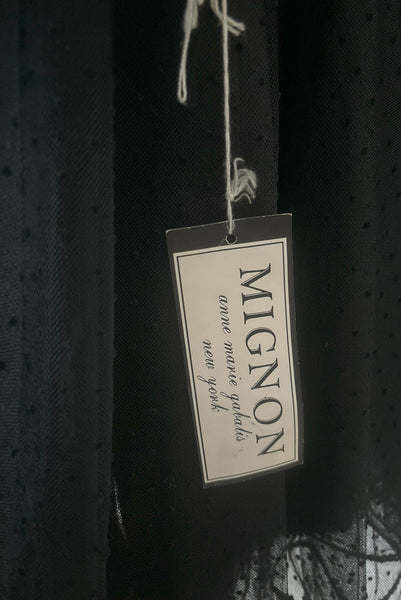 Detail view of 1980s vintage black satin, sequin lace, & dotted tulle asymmetrical cocktail dress by Mignon, small to medium. New with tags. Showing the intact Mignon paper tag.