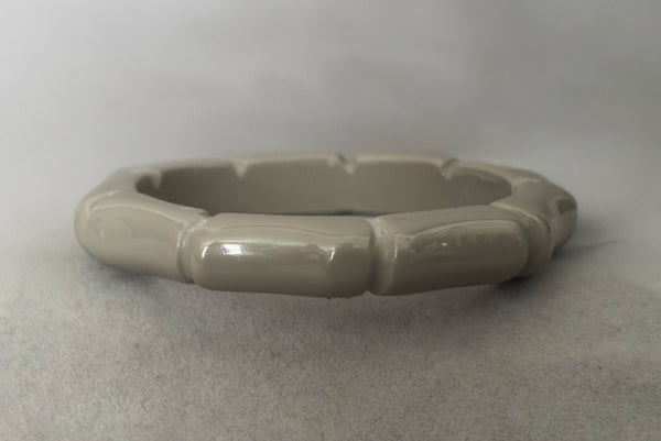 Horizontal front view of 2000s y2k vintage gray plastic molded faux bamboo bangle bracelet.