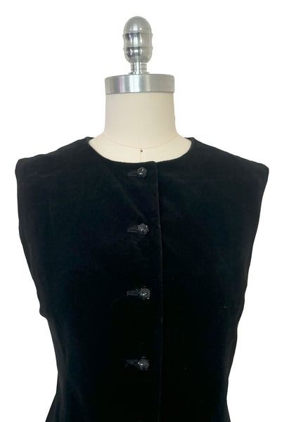 Bodice front view of 1960s vintage black velveteen rhinestone button front drop waist jumper dress, small to medium. Showing the black plastic buttons studded with black rhinestones.