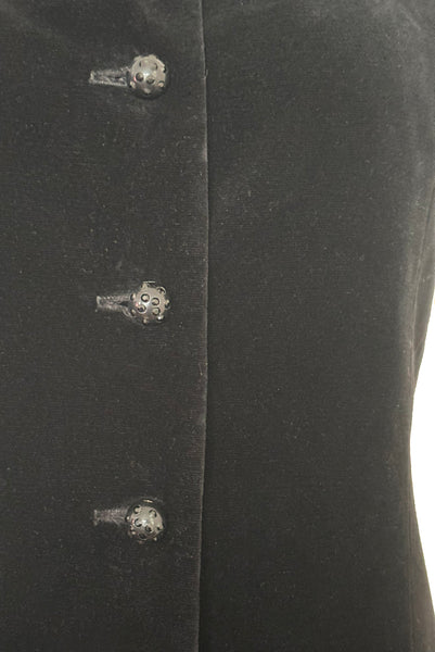 Waist detail view of 1960s vintage black velveteen rhinestone button front drop waist jumper dress, small to medium. Showing the black plastic buttons studded with black rhinestones.