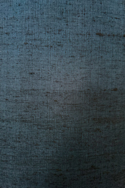 Detail view of 1950s vintage sapphire blue and black raw silk scalloped scoop neck, short sleeve, pencil skirt cocktail dress, size small to medium. Showing a close-up of the slubbed silk fabric.