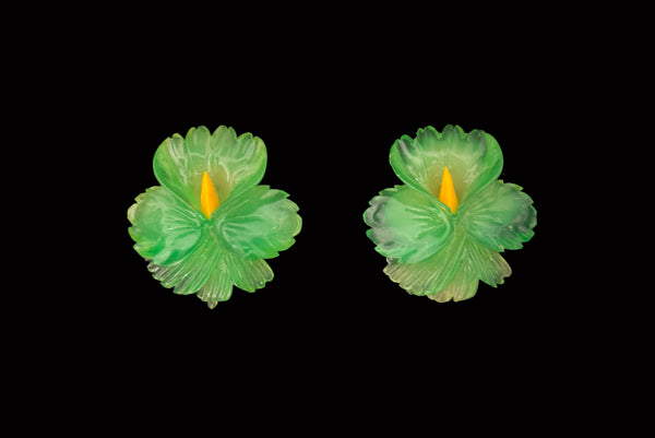 Horizontal front view of 1960s vintage translucent green and yellow Lucite hibiscus tropical floral clip-on earrings.
