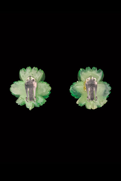 Vertical back view of 1960s vintage translucent green and yellow Lucite hibiscus tropical floral clip-on earrings.