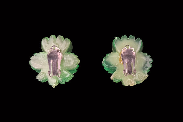 Horizontal back view of 1960s vintage translucent green and yellow Lucite hibiscus tropical floral clip-on earrings.
