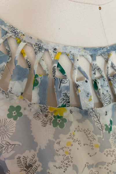 Neckline detail view of 1940s sheer blue nylon green and yellow floral & spiderweb novelty print dress, small to medium. Showing the cut out neckline with the lacing detail.