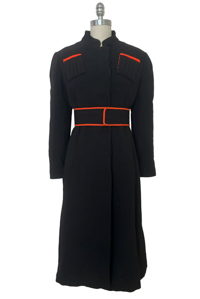 Belted front view of 1970s vintage midi length black and orange wool coat with belt, by Gloria Sachs, size small to medium.