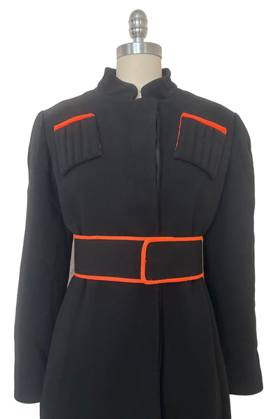 Belted bodice front view of 1970s vintage midi length black and orange wool coat with belt, by Gloria Sachs, size small to medium.