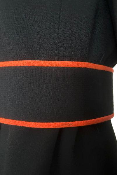 Belt detail view of 1970s vintage midi length black and orange wool coat with belt, by Gloria Sachs, size small to medium. Showing minor moth damage to the belt.