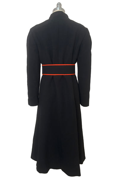 Belted back view of 1970s vintage midi length black and orange wool coat with belt, by Gloria Sachs, size small to medium.