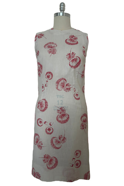 Front view of 1960s vintage crew neck sleeveless white shantung sheath dress with red dandelion novelty floral print, size small to medium.