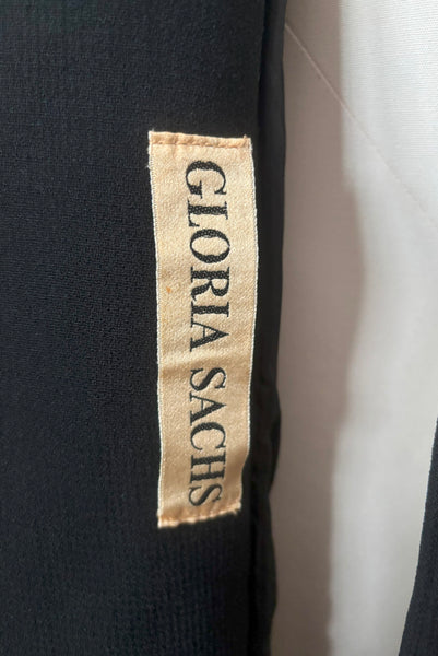 Interior detail view of 1970s vintage midi length black and orange wool coat with belt, by Gloria Sachs, size small to medium. Showing the Gloria Sachs label.