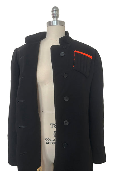 Open bodice front view of 1970s vintage midi length black and orange wool coat with belt, by Gloria Sachs, size small to medium.