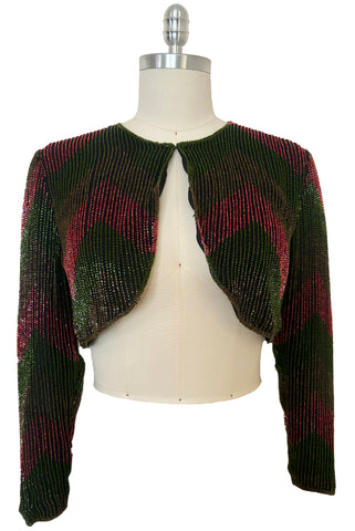 Front view of vintage 1970s black silk bolero embellished with green, red, and yellow chevron pattern glass beads, small to medium.