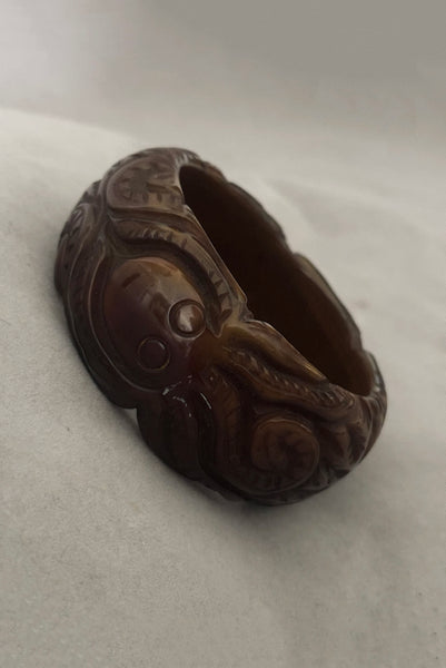 Vertical perspective view of 1930s vintage novelty octopus sea life carved green Bakelite statement bangle bracelet.