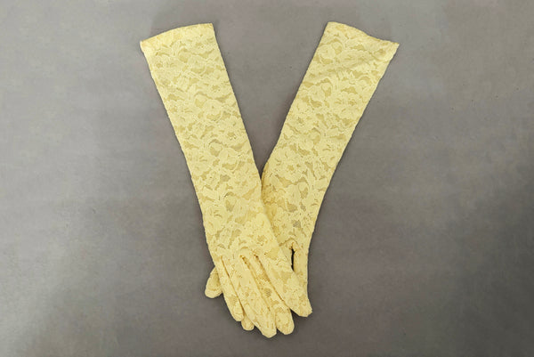 Horizontal pair view of 1960s vintage below elbow yellow stretch lace gloves.
