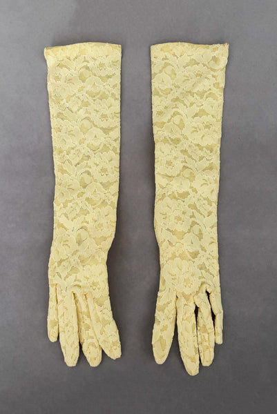 Vertical front view of 1960s vintage below elbow yellow stretch lace gloves.
