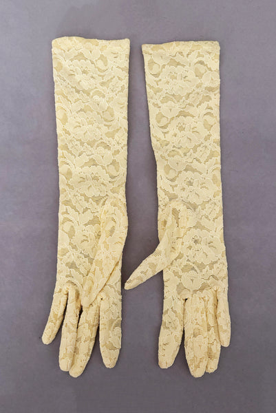 Vertical back view of 1960s vintage below elbow yellow stretch lace gloves.