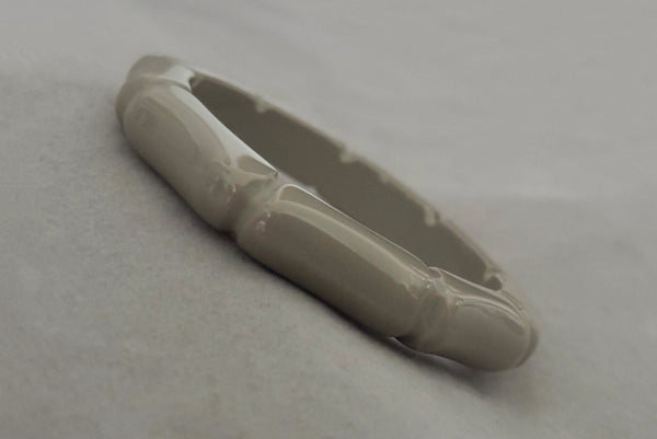 Horizontal perspective view of 2000s y2k vintage gray plastic molded faux bamboo bangle bracelet.