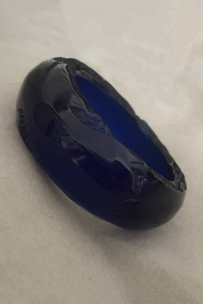 Vertical perspective view of 1980s vintage artisan carved translucent blue Lucite asymmetrical bangle bracelet.