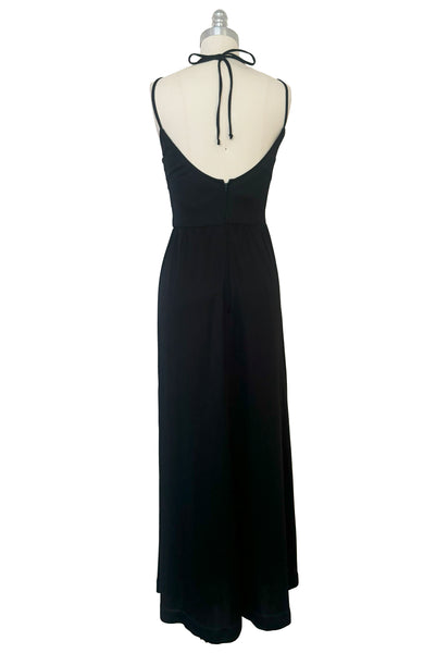 Back view of vintage 1970s black knit strappy maxi dress, extra small to small. Showing the multiple straps, scoop bodice back, and gathered floor length skirt.