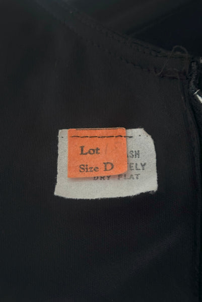Interior detail view of vintage 1970s black knit strappy maxi dress, extra small to small. Showing the tags.