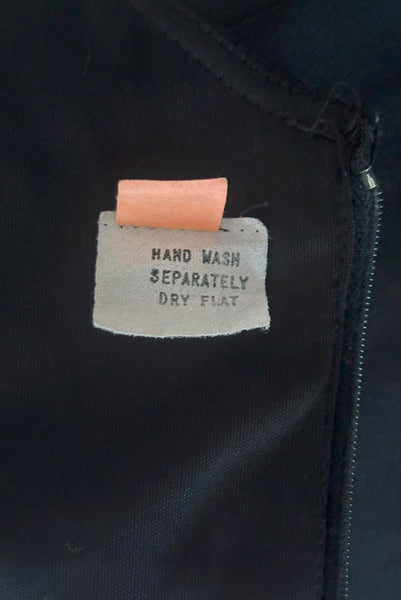 Interior detail view of vintage 1970s black knit strappy maxi dress, extra small to small. Showing the tags.